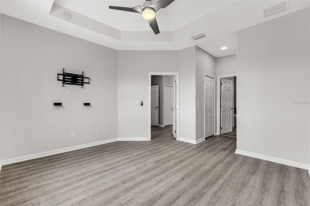 1628 Portofino Meadows Blvd, Orlando, FL 32824 - empty room with wood finished floors, baseboards, ceiling fan, a tray ceiling, and recessed lighting