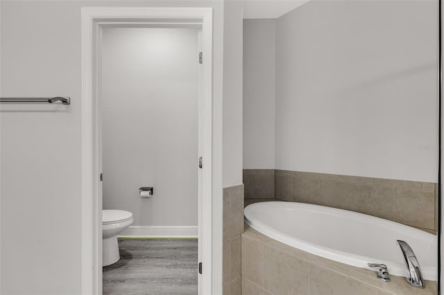 1628 Portofino Meadows Blvd, Orlando, FL 32824 - bathroom with a garden tub, toilet, baseboards, and wood finished floors