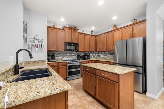 1760 Boat Launch Rd, Kissimmee, FL 34746 - kitchen featuring stainless steel appliances, a sink, backsplash, brown cabinetry, and light stone counters