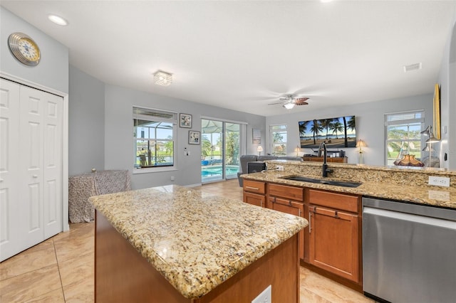 1760 Boat Launch Rd, Kissimmee, FL 34746 - kitchen with dishwasher, a sink, brown cabinetry, open floor plan, and light tile patterned floors