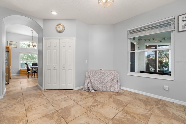 1760 Boat Launch Rd, Kissimmee, FL 34746 - entrance foyer with arched walkways, light tile patterned floors, baseboards, a textured ceiling, and a chandelier
