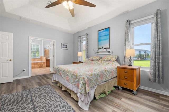1760 Boat Launch Rd, Kissimmee, FL 34746 - bedroom with wood finished floors, baseboards, a tray ceiling, ensuite bathroom, and a ceiling fan