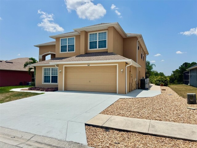 315 Wildflower Rd, Davenport, FL 33837 - view of front facade featuring concrete driveway, stucco siding, a garage, and central air condition unit