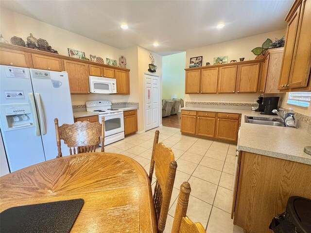 315 Wildflower Rd, Davenport, FL 33837 - kitchen featuring white appliances, a sink, light tile patterned floors, light countertops, and brown cabinets