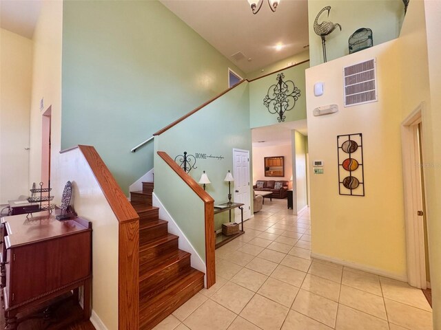 315 Wildflower Rd, Davenport, FL 33837 - staircase with a towering ceiling, tile patterned floors, and baseboards