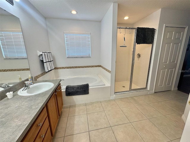 315 Wildflower Rd, Davenport, FL 33837 - full bathroom featuring tile patterned flooring, a garden tub, vanity, a stall shower, and a textured ceiling
