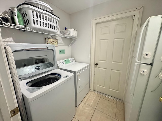 315 Wildflower Rd, Davenport, FL 33837 - washroom with washer and clothes dryer and light tile patterned floors