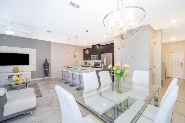 4903 Windermere Ave, Kissimmee, FL 34746 - dining space with light marble finish flooring, a chandelier, ceiling fan, and baseboards