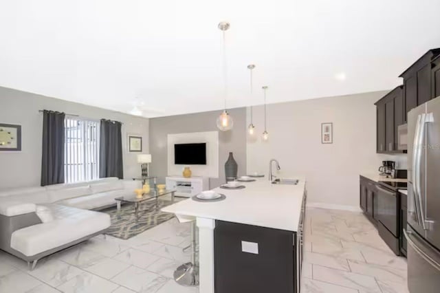 4903 Windermere Ave, Kissimmee, FL 34746 - kitchen with light marble finish flooring, electric range, a sink, freestanding refrigerator, and a center island with sink