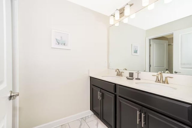 4903 Windermere Ave, Kissimmee, FL 34746 - bathroom featuring double vanity, marble look tiles, and baseboards