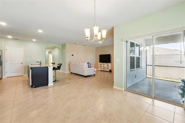 2416 White Poppy Dr, Kissimmee, FL 34747 - living area featuring arched walkways, a chandelier, baseboards, recessed lighting, and light tile patterned floors