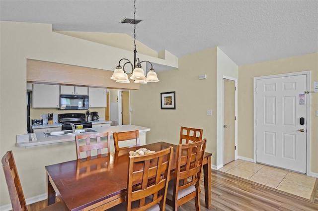 3151 Britannia Blvd Unit C, Kissimmee, FL 34747 - dining room with vaulted ceiling, a chandelier, light wood finished floors, baseboards, and a textured ceiling