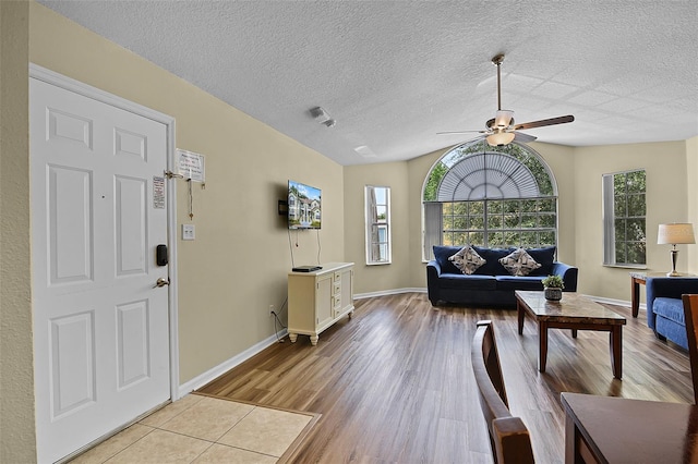 3151 Britannia Blvd Unit C, Kissimmee, FL 34747 - living area with a ceiling fan, light wood-type flooring, lofted ceiling, a textured ceiling, and baseboards