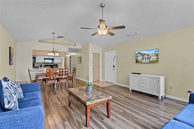 3151 Britannia Blvd Unit C, Kissimmee, FL 34747 - living area with wood finished floors, vaulted ceiling, a ceiling fan, a chandelier, and baseboards