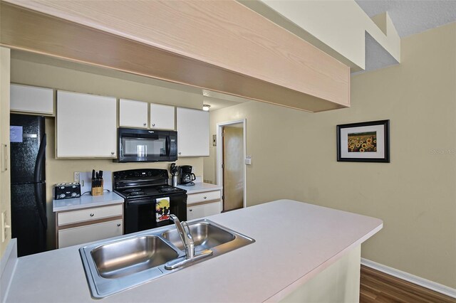 3151 Britannia Blvd Unit C, Kissimmee, FL 34747 - kitchen featuring black appliances, light countertops, dark wood-type flooring, and white cabinets