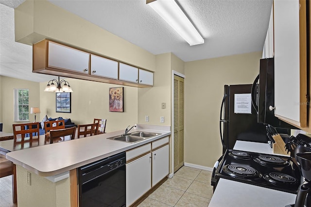 3151 Britannia Blvd Unit C, Kissimmee, FL 34747 - kitchen with black appliances, a sink, a textured ceiling, a peninsula, and light countertops