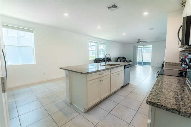3442 Monaco Ln, Davenport, FL 33897 - kitchen with stainless steel appliances, open floor plan, stone counters, white cabinets, and light tile patterned floors