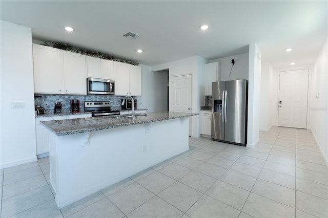 3442 Monaco Ln, Davenport, FL 33897 - kitchen featuring stainless steel appliances, tasteful backsplash, stone countertops, a kitchen bar, and white cabinetry
