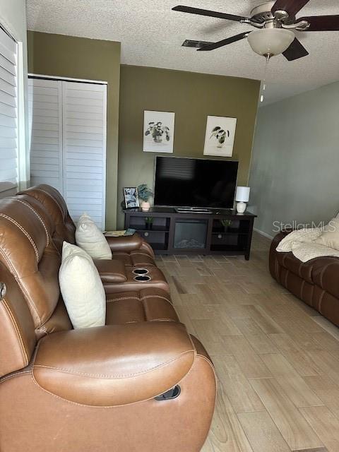 13 W Marbrisa Way, Kissimmee, FL 34743 - living area featuring a ceiling fan, wood finished floors, a textured ceiling, and baseboards