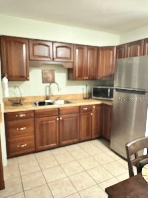 13 W Marbrisa Way, Kissimmee, FL 34743 - kitchen with appliances with stainless steel finishes, a sink, light countertops, and light tile patterned flooring