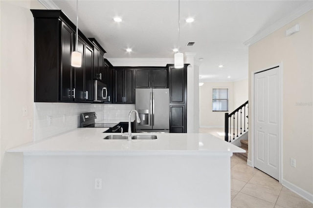 1312 Royal St George Blvd, Davenport, FL 33896 - kitchen with appliances with stainless steel finishes, dark cabinetry, a sink, a peninsula, and crown molding