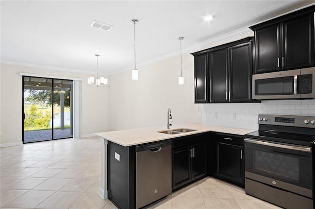 1312 Royal St George Blvd, Davenport, FL 33896 - kitchen with stainless steel appliances, dark cabinetry, a sink, light tile patterned floors, and crown molding