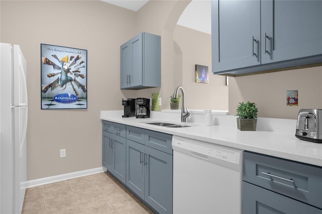 2307 Silver Palm Dr Unit 304, Kissimmee, FL 34747 - kitchen with white appliances, a sink, light countertops, and arched walkways