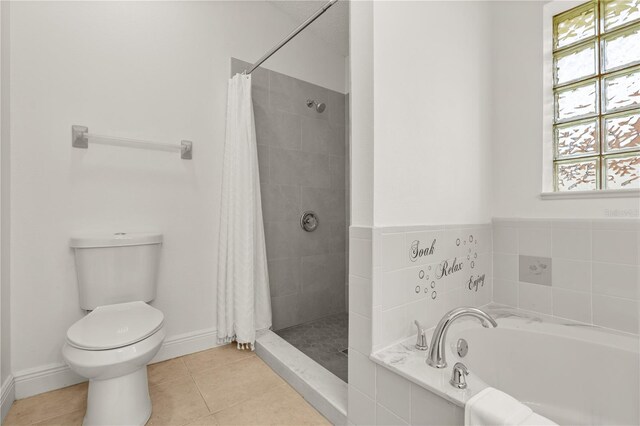 1914 Ellery Ln, Kissimmee, FL 34746 - bathroom featuring toilet, a garden tub, tiled shower, tile patterned flooring, and baseboards