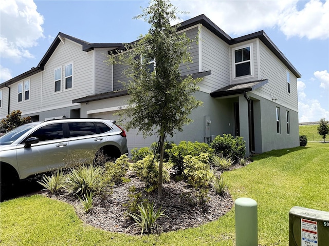 2086 Crape Jasmine Ln, Orlando, FL 32824 - view of property exterior with a garage, a yard, and stucco siding