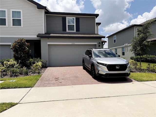 2086 Crape Jasmine Ln, Orlando, FL 32824 - traditional-style house featuring a garage and decorative driveway