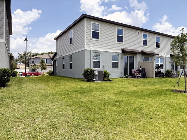 2086 Crape Jasmine Ln, Orlando, FL 32824 - back of house with a lawn, stucco siding, and central AC unit