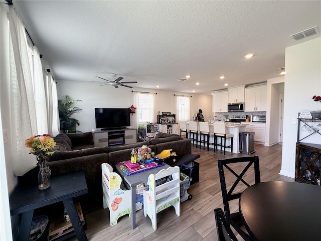 2086 Crape Jasmine Ln, Orlando, FL 32824 - living room with ceiling fan, recessed lighting, a textured ceiling, and wood finished floors