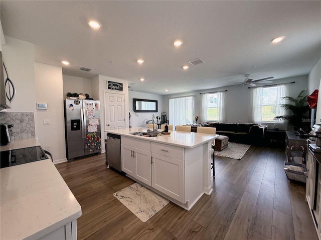 2086 Crape Jasmine Ln, Orlando, FL 32824 - kitchen with stainless steel appliances, a sink, dark wood-style floors, white cabinets, and light countertops