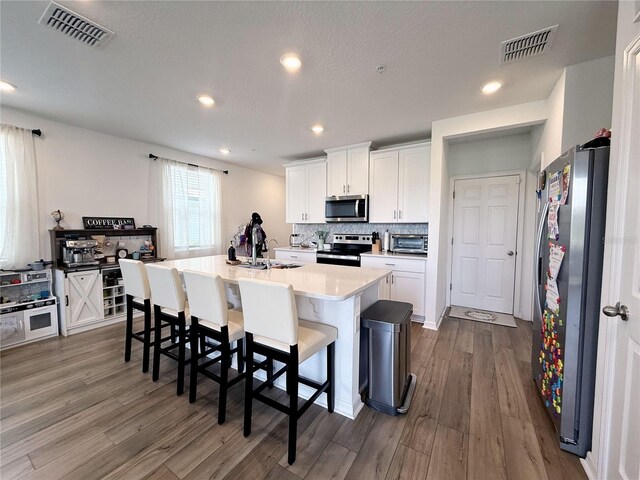 2086 Crape Jasmine Ln, Orlando, FL 32824 - kitchen featuring stainless steel appliances, dark wood-style flooring, white cabinets, and recessed lighting