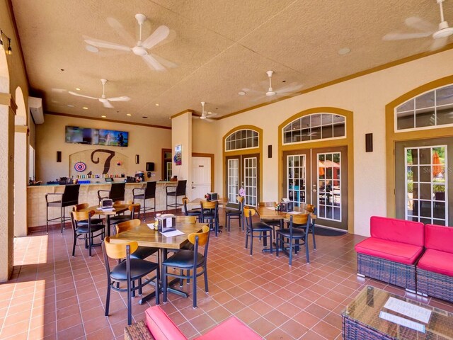 1375 Tuscana Ln Unit 1405, Davenport, FL 33896 - dining area featuring french doors, a ceiling fan, tile patterned flooring, crown molding, and a textured ceiling