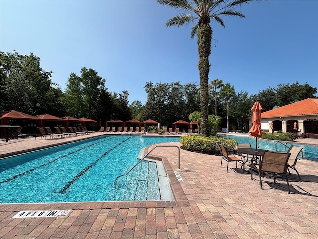 1375 Tuscana Ln Unit 1405, Davenport, FL 33896 - community pool featuring a patio and view of scattered trees