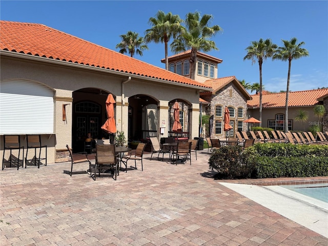 1375 Tuscana Ln Unit 1405, Davenport, FL 33896 - rear view of house with outdoor dining area, a tile roof, stucco siding, and a patio