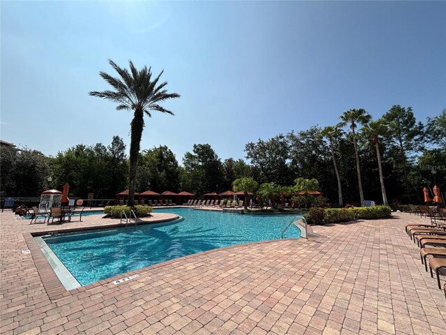 1375 Tuscana Ln Unit 1405, Davenport, FL 33896 - community pool featuring a patio and view of scattered trees