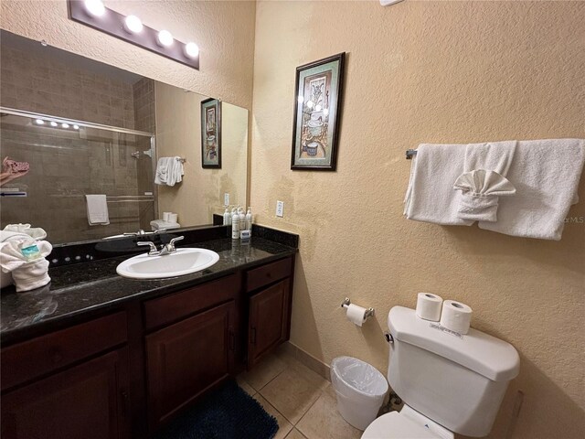 1375 Tuscana Ln Unit 1405, Davenport, FL 33896 - bathroom featuring tile patterned floors, toilet, vanity, tiled shower, and a textured wall