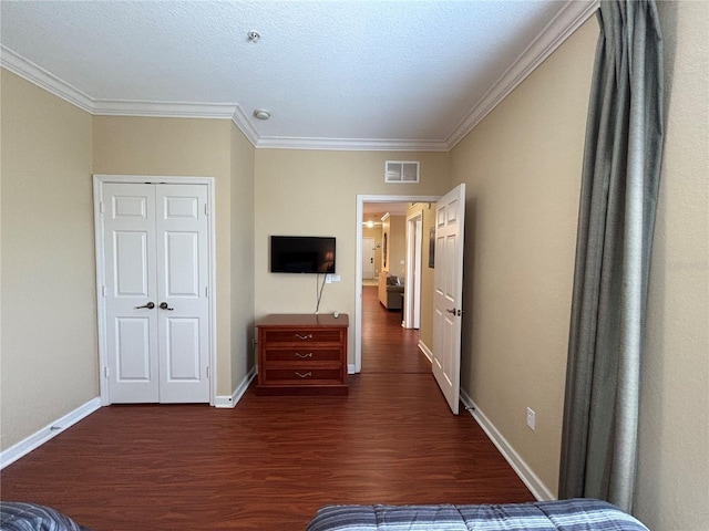 1375 Tuscana Ln Unit 1405, Davenport, FL 33896 - bedroom featuring dark wood-style floors, crown molding, baseboards, and a closet