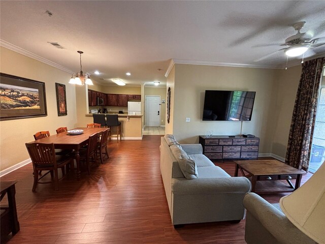 1375 Tuscana Ln Unit 1405, Davenport, FL 33896 - living room featuring ornamental molding, dark wood-type flooring, baseboards, a ceiling fan, and a chandelier