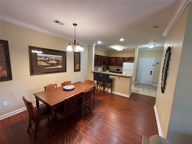 1375 Tuscana Ln Unit 1405, Davenport, FL 33896 - dining area featuring crown molding, wood finished floors, baseboards, a chandelier, and recessed lighting