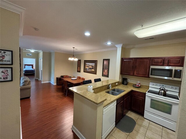 1375 Tuscana Ln Unit 1405, Davenport, FL 33896 - kitchen featuring white appliances, a sink, a peninsula, crown molding, and a chandelier