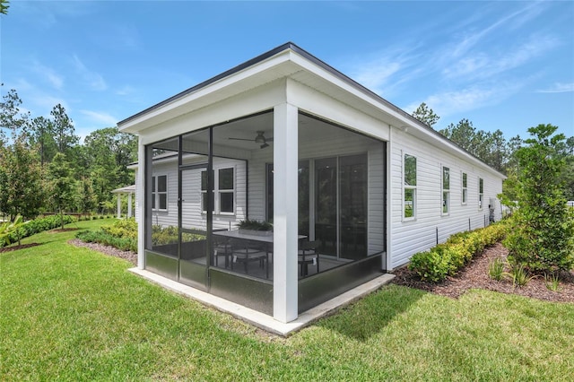 9211 Players Dr, Weeki Wachee, FL 34613 - back of property with a sunroom, a lawn, and a ceiling fan