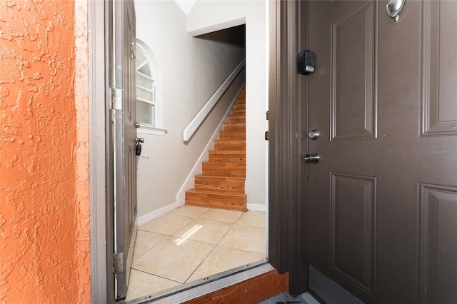437 Fountainhead Cir Unit 283, Kissimmee, FL 34741 - entryway with light tile patterned flooring, stairway, and baseboards
