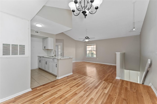 437 Fountainhead Cir Unit 283, Kissimmee, FL 34741 - kitchen with a sink, light wood-style flooring, a ceiling fan, white cabinets, and vaulted ceiling