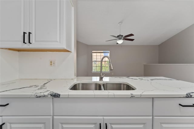 437 Fountainhead Cir Unit 283, Kissimmee, FL 34741 - kitchen featuring a sink, ceiling fan, white cabinets, light stone countertops, and vaulted ceiling