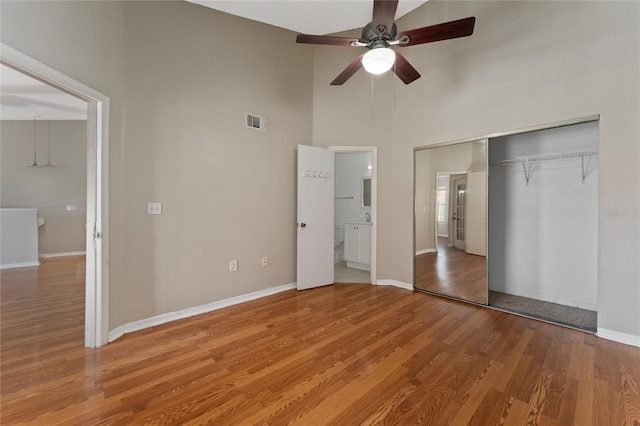 437 Fountainhead Cir Unit 283, Kissimmee, FL 34741 - unfurnished bedroom featuring wood finished floors, baseboards, a high ceiling, and a closet