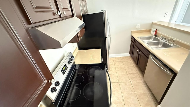 4728 Walden Cir Unit 32, Orlando, FL 32811 - kitchen with stainless steel dishwasher, light countertops, range with electric stovetop, freestanding refrigerator, and light tile patterned flooring