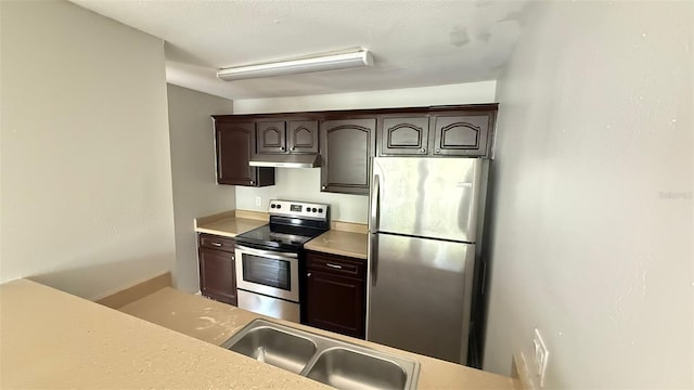 4728 Walden Cir Unit 32, Orlando, FL 32811 - kitchen featuring stainless steel appliances, under cabinet range hood, dark brown cabinets, and light countertops